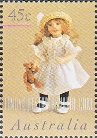 FindYourStampsValue: Doll wearing white dress holding teddy bear